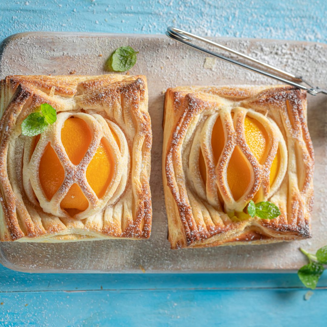 Awesome puff pastry with peaches and mint. Unique yummy cake. French cuisine.