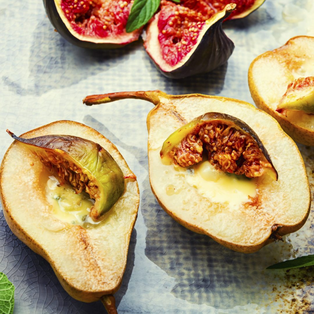 Baked pear halves with figs stuffed with cheese.Autumn snack.
